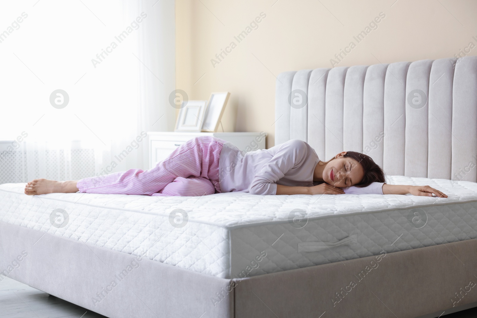 Woman sleeping on bed with orthopedic mattress at home Photo of Woman sleeping on bed with orthopedic mattress at home