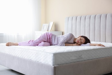 Photo of Woman sleeping on bed with orthopedic mattress at home