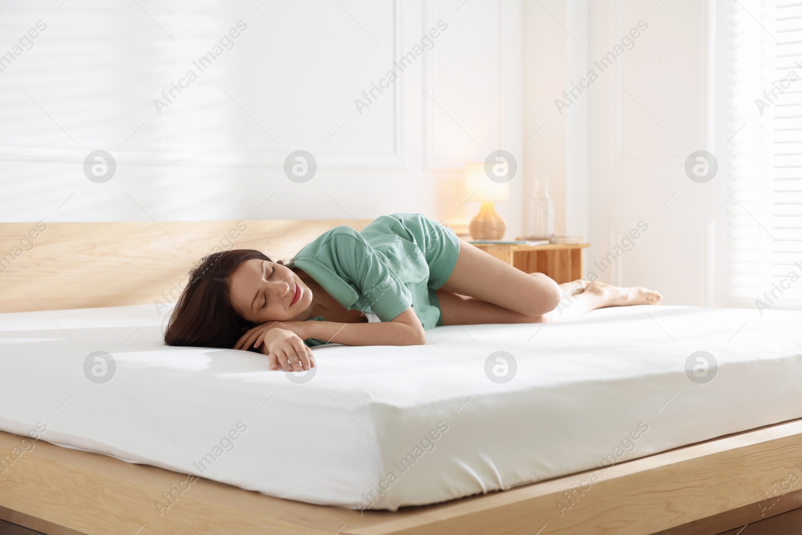 Woman sleeping on bed with orthopedic mattress at home Photo of Woman sleeping on bed with orthopedic mattress at home
