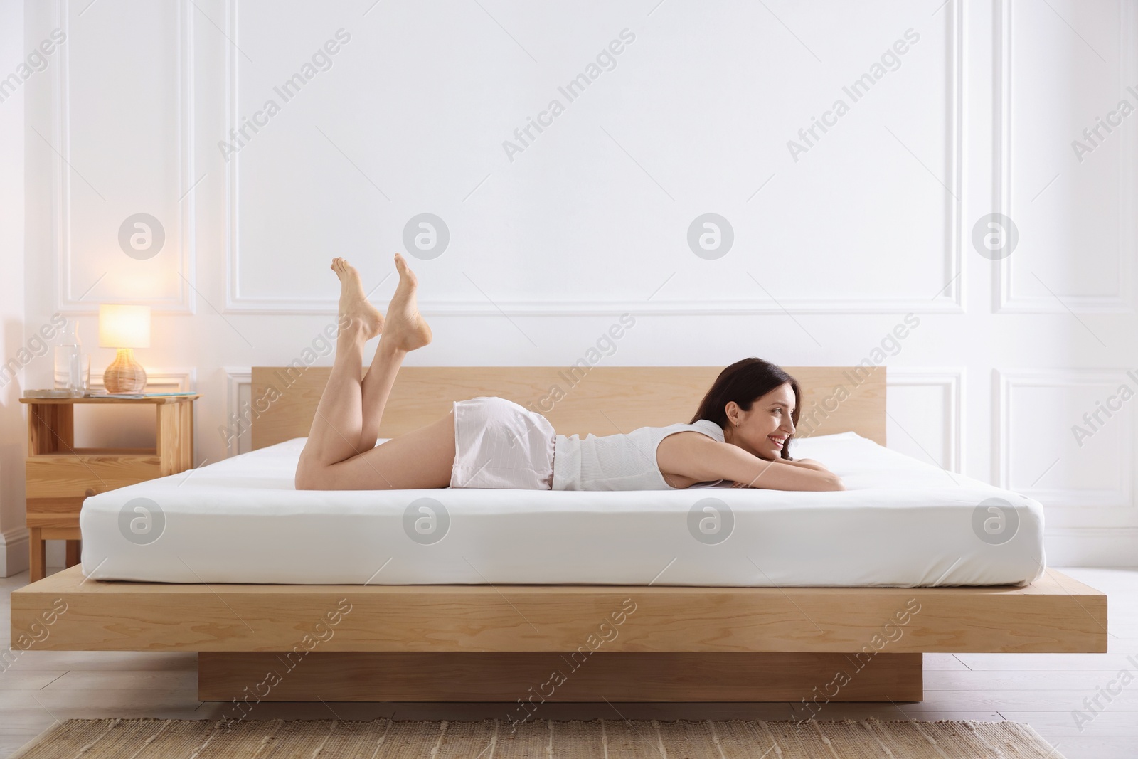 Woman lying on bed with orthopedic mattress at home Photo of Woman lying on bed with orthopedic mattress at home