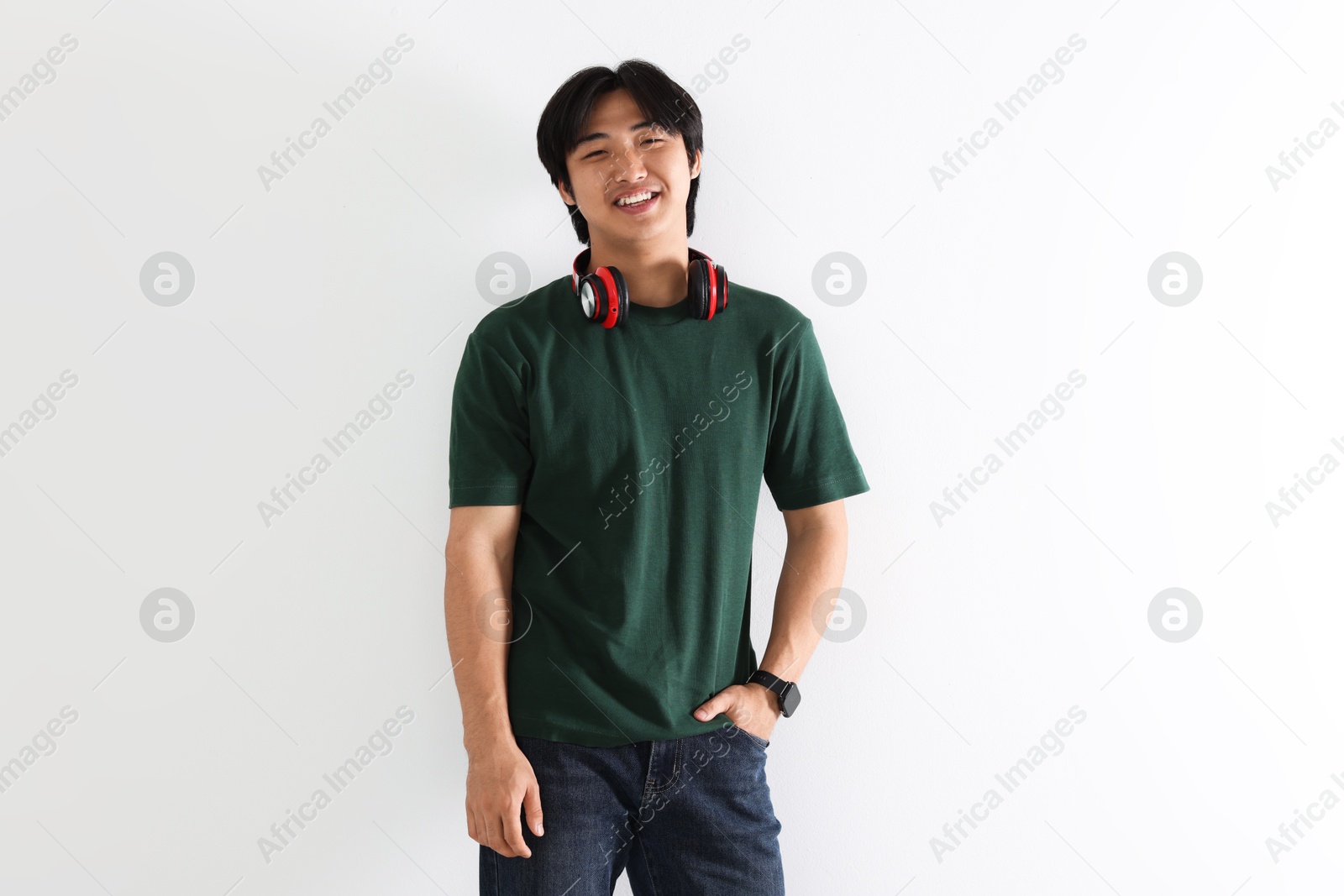Smiling Asian man with headphones on white background Photo of Smiling Asian man with headphones on white background