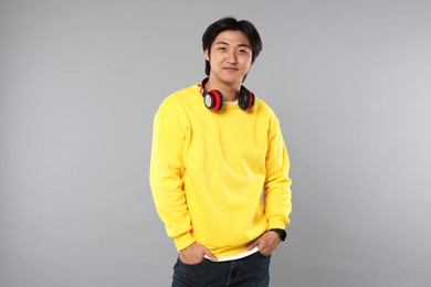 Photo of Handsome Asian man with headphones on grey background