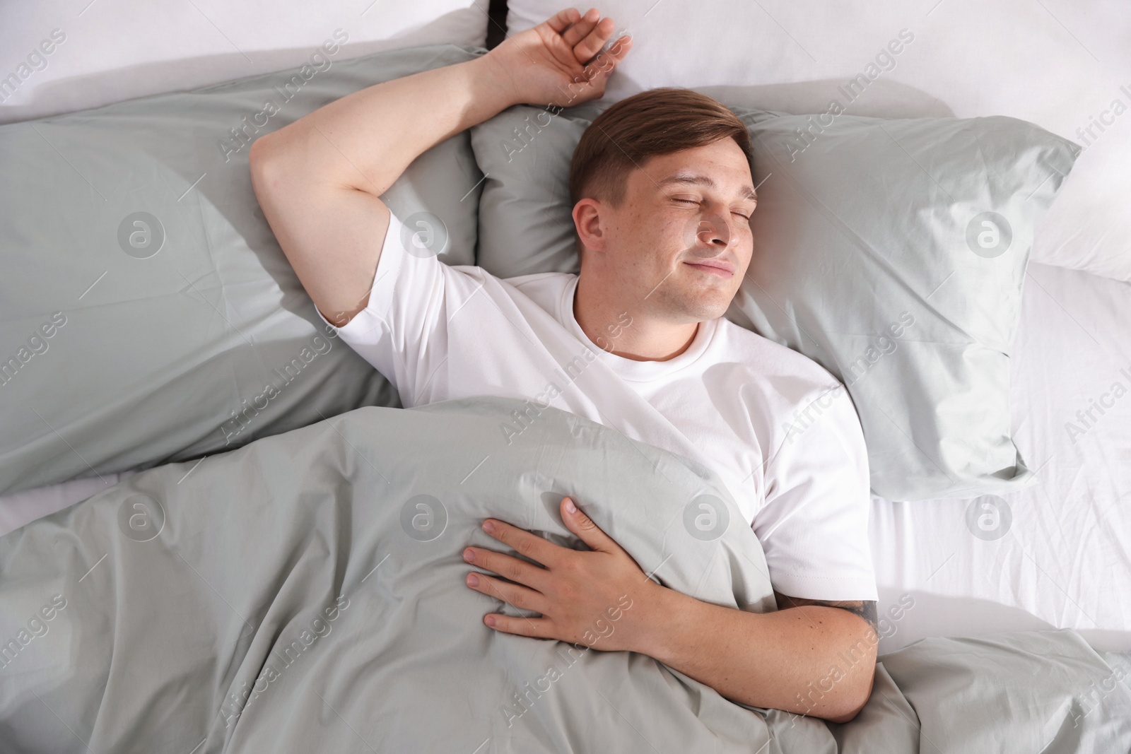 Young man sleeping on bed with soft mattress at home, top view Photo of Young man sleeping on bed with soft mattress at home, top view