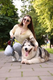 Photo of Happy woman with her cute Alaskan malamute dog in park