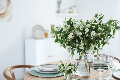 Photo of Bouquet of beautiful jasmine flowers on dining table indoors. Space for text