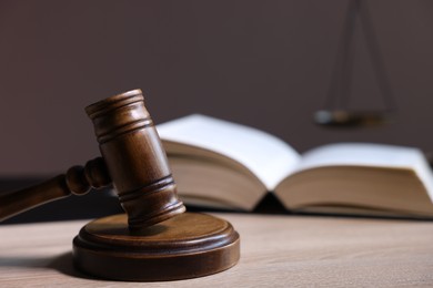 Photo of Judge's gavel and book on wooden table, closeup