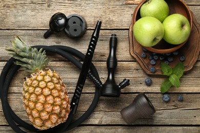 Photo of Traditional hookah parts, charcoal rings, fruits, blueberries and mint on wooden table, flat lay