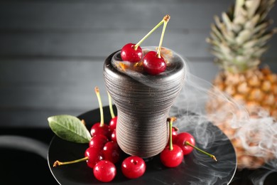 Photo of Hookah with cherries and smoke on black background, closeup