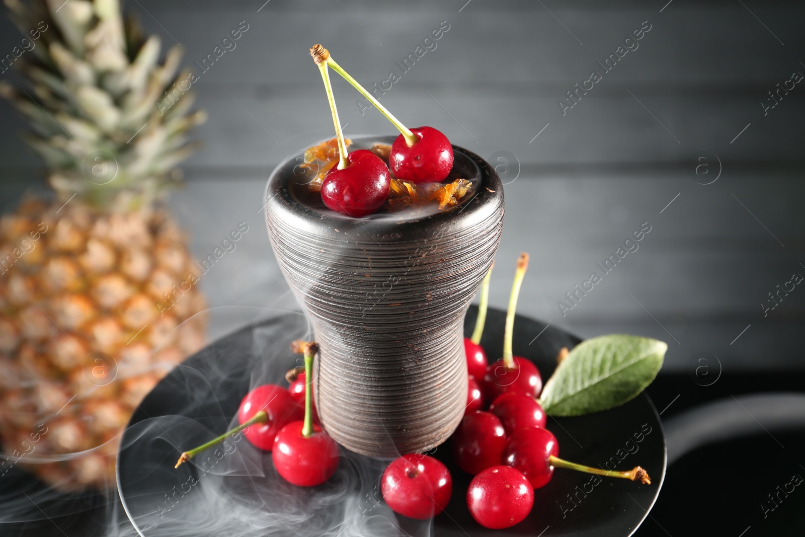 Photo of Hookah with cherries and smoke on black background, closeup