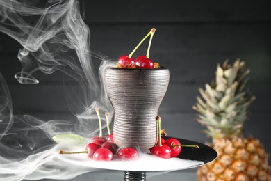 Photo of Hookah with cherries and smoke on black background, closeup