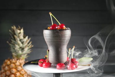 Photo of Hookah with cherries and smoke on black background, closeup