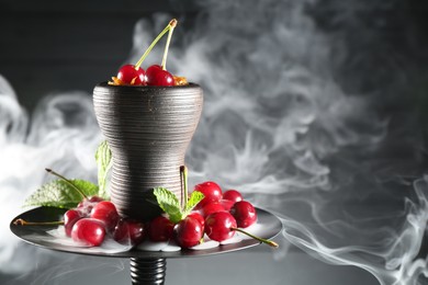 Photo of Hookah with cherries and smoke on black background, closeup. Space for text