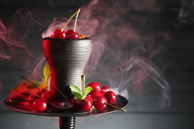 Photo of Hookah with cherries and smoke on black background, closeup. Space for text