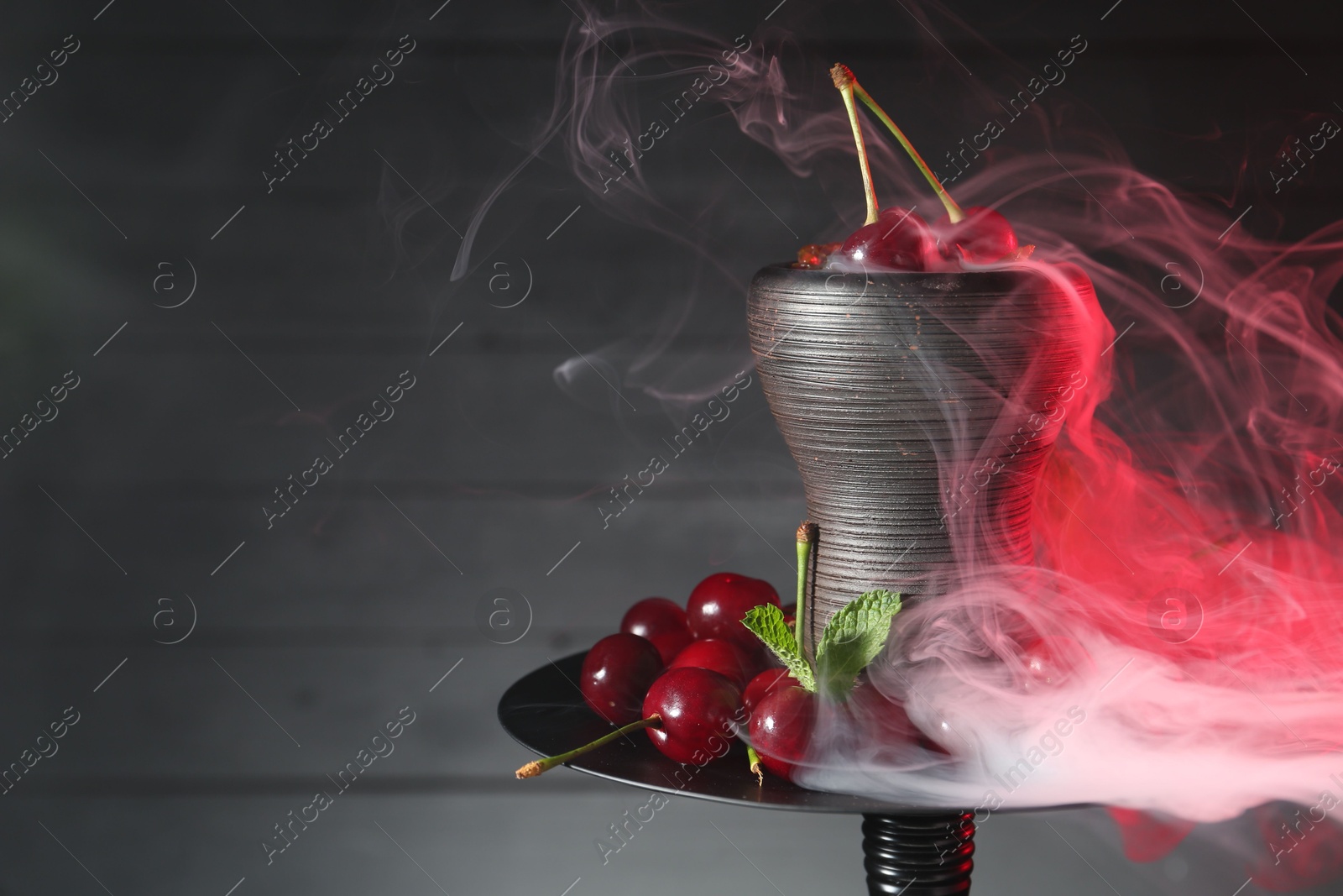Photo of Hookah with cherries and smoke on black background, closeup. Space for text