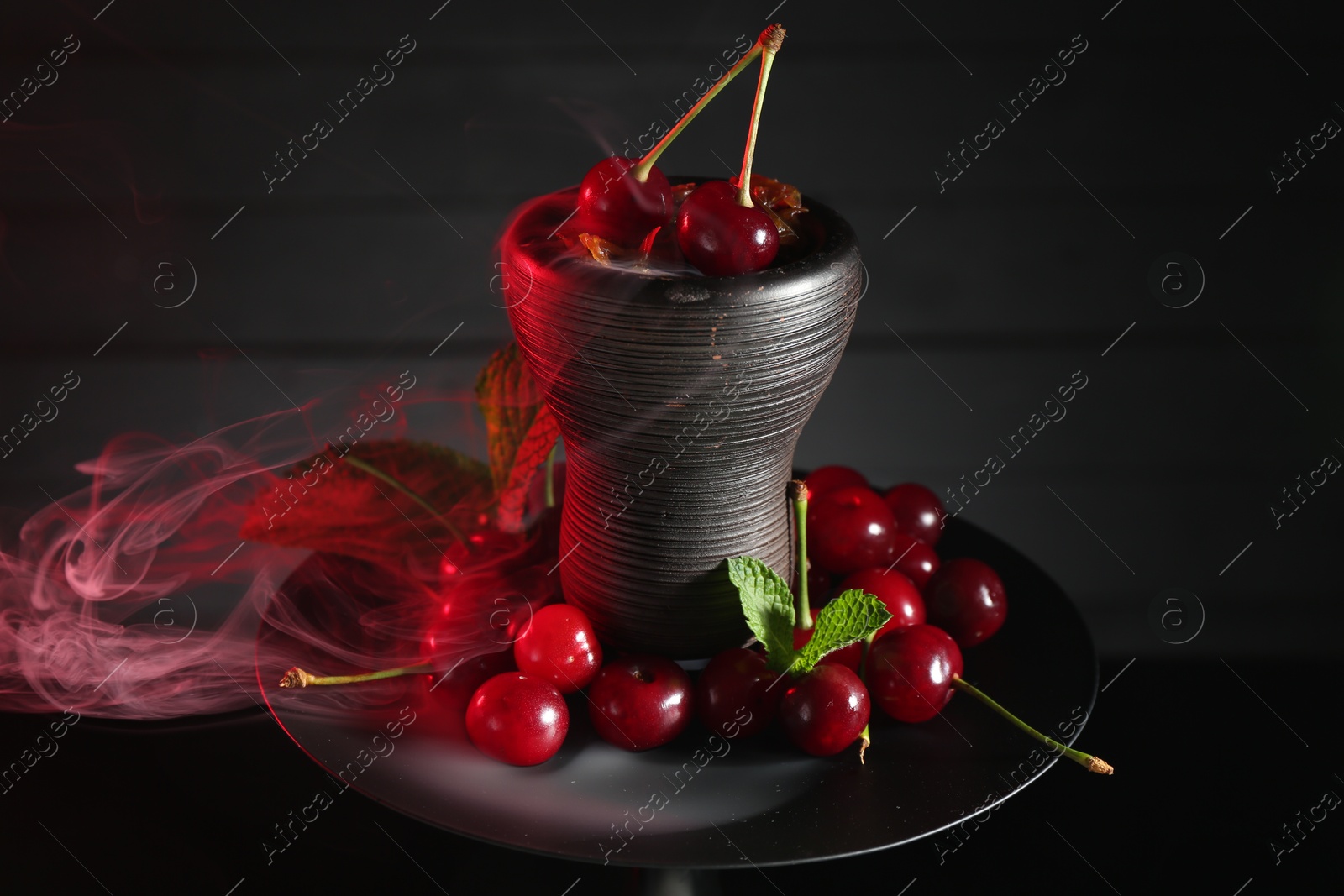 Photo of Hookah with cherries and smoke on black background, closeup