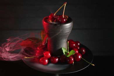 Photo of Hookah with cherries and smoke on black background, closeup