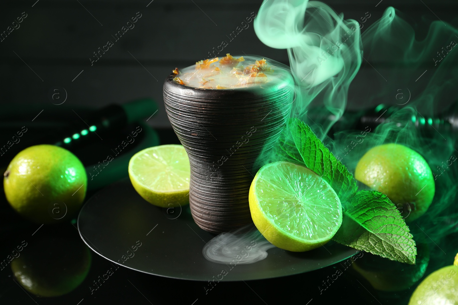 Hookah bowl with limes, mint and smoke on black table, closeup Photo of Hookah bowl with limes, mint and smoke on black table, closeup