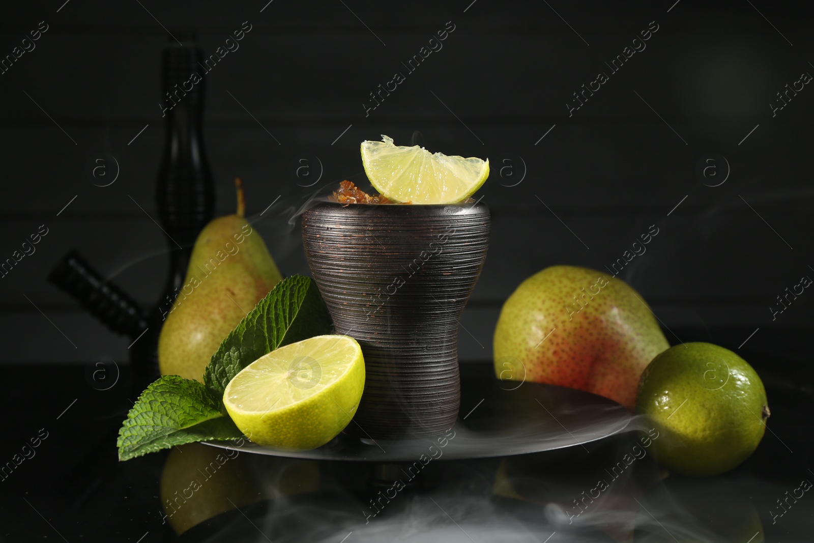 Hookah bowl with fruits, mint and smoke on black table, closeup Photo of Hookah bowl with fruits, mint and smoke on black table, closeup