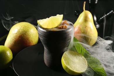 Photo of Hookah bowl with fruits, mint and smoke on black table, closeup