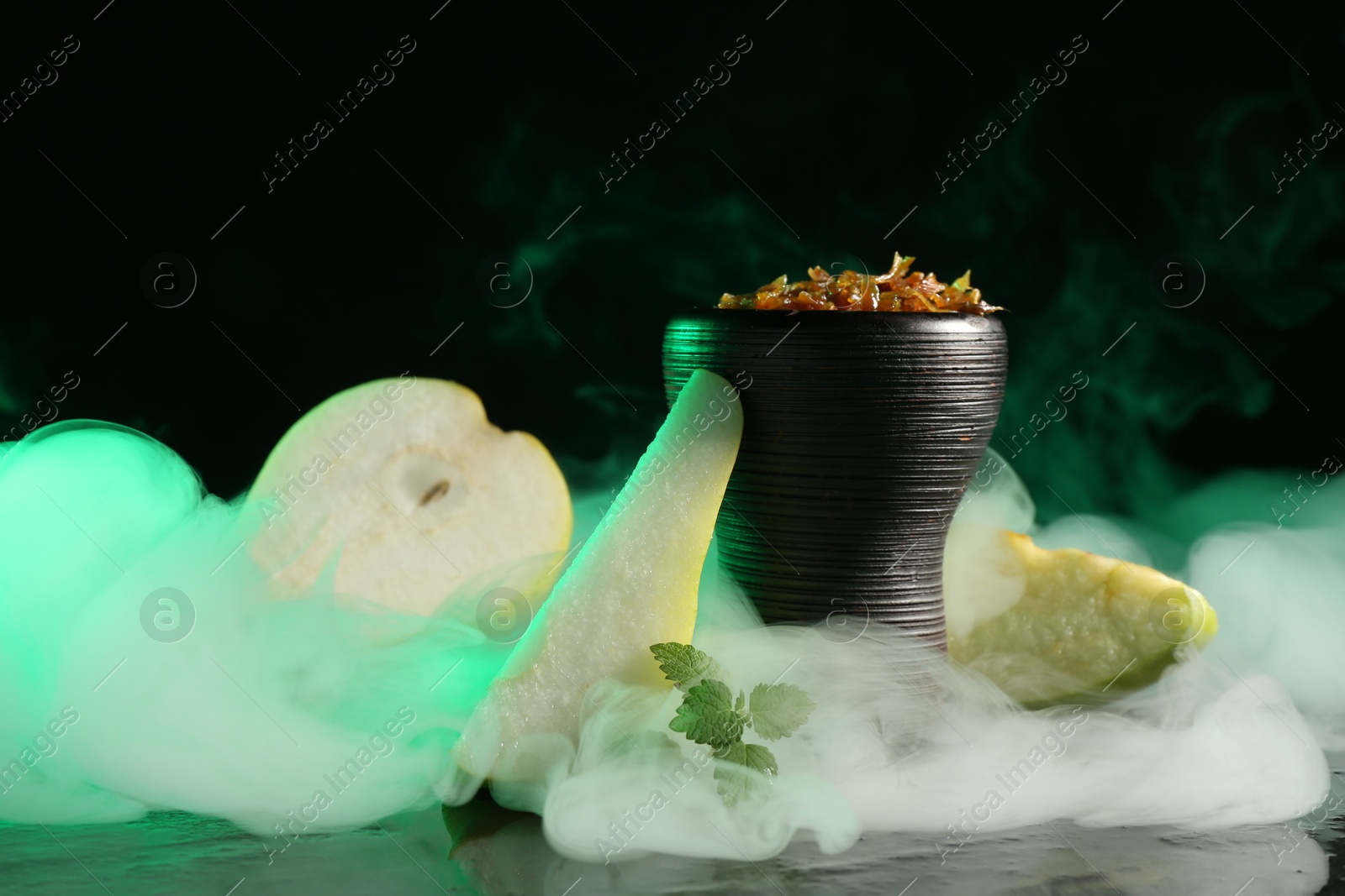 Hookah bowl with pear pieces, mint and smoke on black table, closeup Photo of Hookah bowl with pear pieces, mint and smoke on black table, closeup