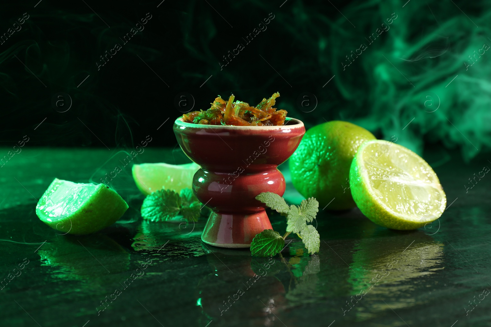 Hookah bowl with limes, mint and smoke on black table, closeup Photo of Hookah bowl with limes, mint and smoke on black table, closeup