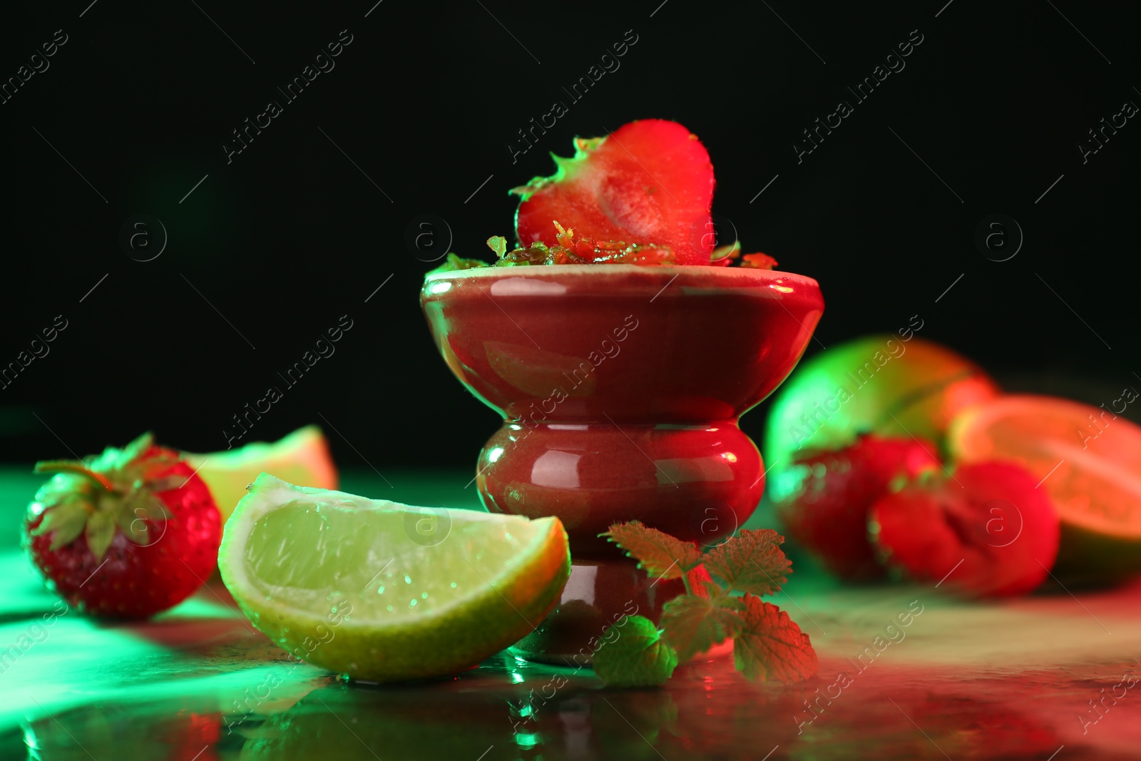 Hookah bowl with limes, strawberries, mint and smoke on black table, closeup Photo of Hookah bowl with limes, strawberries, mint and smoke on black table, closeup