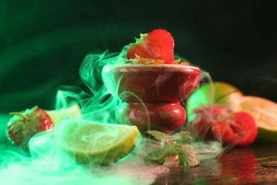 Photo of Hookah bowl with limes, strawberries, mint and smoke on black table, closeup