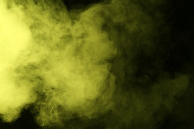 Photo of Hookah smoke in yellow light on black background, closeup