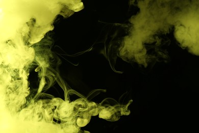 Photo of Hookah smoke in yellow light on black background, closeup