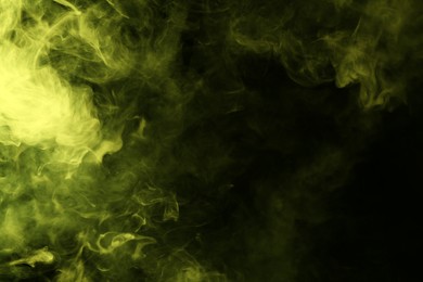 Photo of Hookah smoke in yellow light on black background, closeup