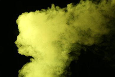 Photo of Hookah smoke in yellow light on black background, closeup