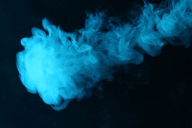 Photo of Hookah smoke in blue light on black background, closeup