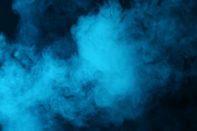Photo of Hookah smoke in blue light on black background, closeup