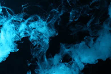 Photo of Hookah smoke in blue light on black background, closeup