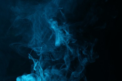 Photo of Hookah smoke in blue light on black background, closeup