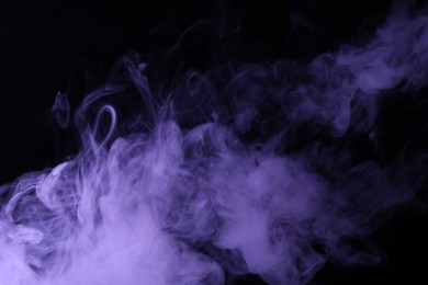 Photo of Hookah smoke in violet light on black background, closeup
