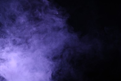 Photo of Hookah smoke in violet light on black background, closeup