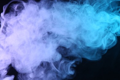 Photo of Hookah smoke in color lights on black background, closeup