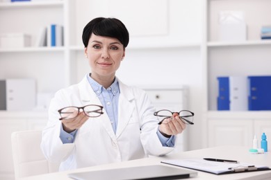 Photo of Portrait of professional ophthalmologist at white table in clinic