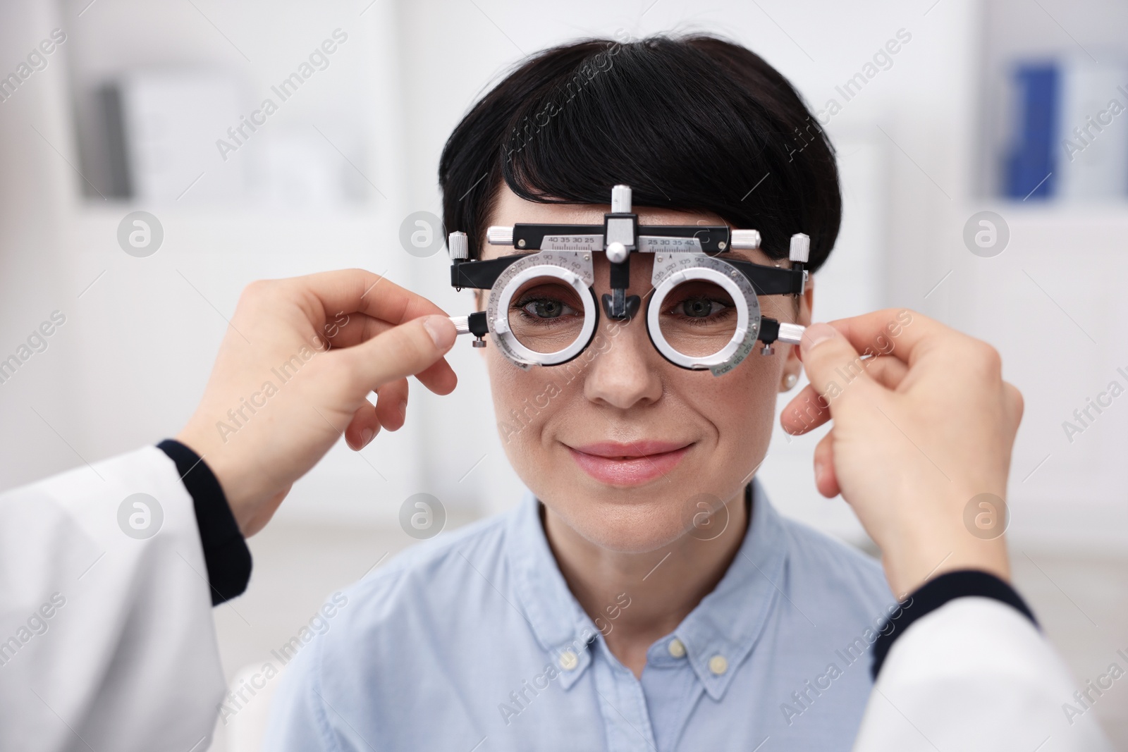 Ophthalmologist examining patient's vision with trial frame in clinic, closeup Photo of Ophthalmologist examining patient's vision with trial frame in clinic, closeup