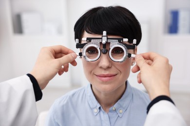 Photo of Ophthalmologist examining patient's vision with trial frame in clinic, closeup