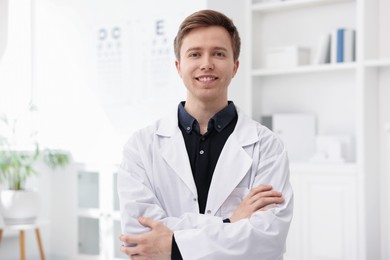 Photo of Portrait of professional ophthalmologist with crossed arms in clinic