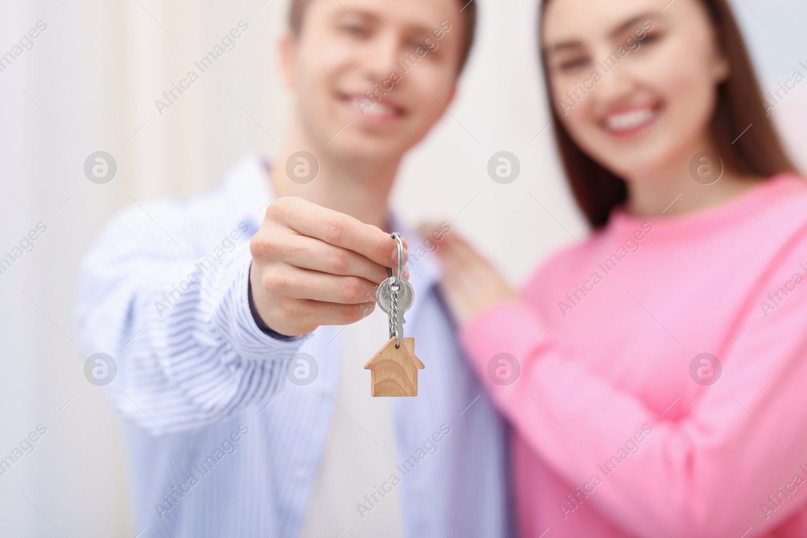 Happy couple with key of their new apartment indoors, selective focus Photo of Happy couple with key of their new apartment indoors, selective focus