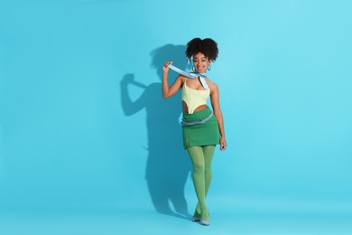 Photo of Fashionable portrait of beautiful Brazilian woman in stylish outfit on light blue background