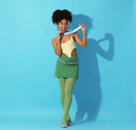 Photo of Fashionable portrait of beautiful Brazilian woman in stylish outfit on light blue background