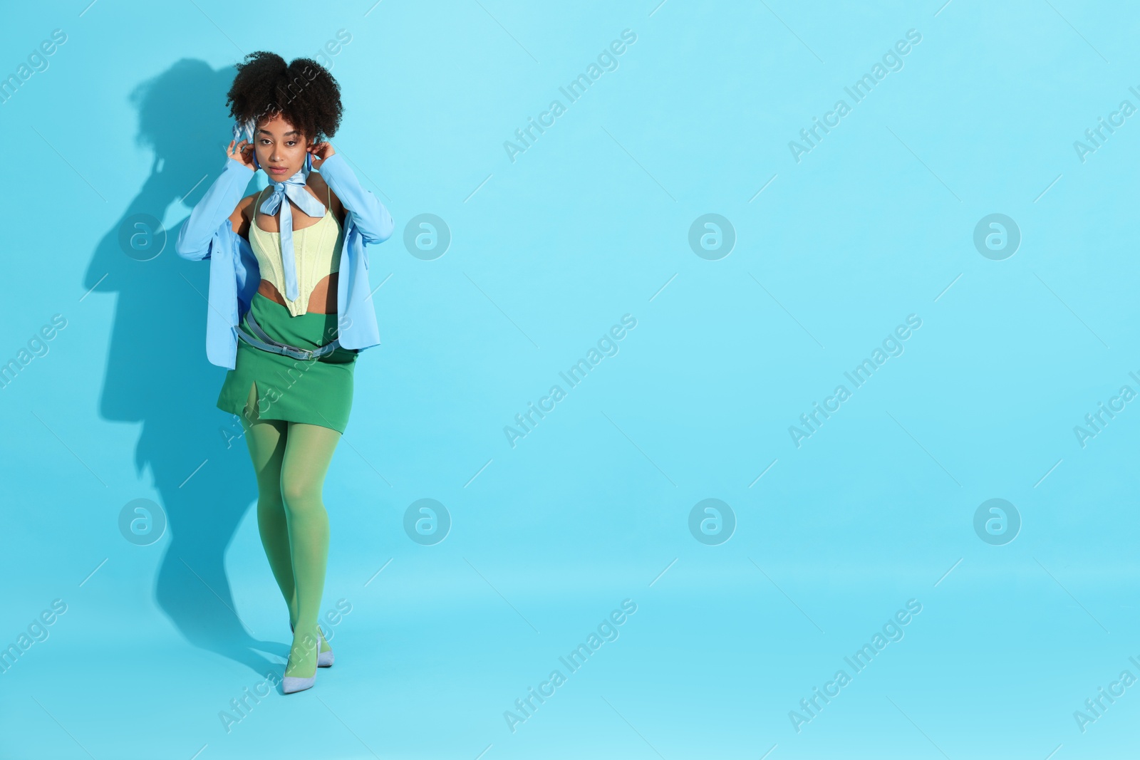 Fashionable portrait of beautiful Brazilian woman in stylish outfit on light blue background. Space for text Photo of Fashionable portrait of beautiful Brazilian woman in stylish outfit on light blue background. Space for text