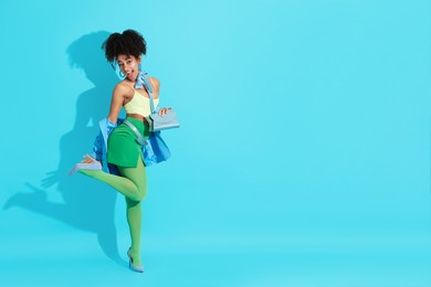 Photo of Fashionable portrait of beautiful Brazilian woman in stylish outfit on light blue background. Space for text