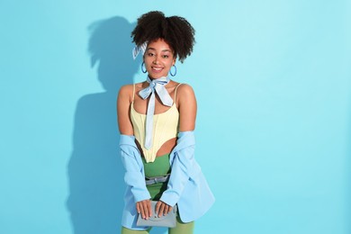 Photo of Fashionable portrait of beautiful Brazilian woman in stylish outfit on light blue background