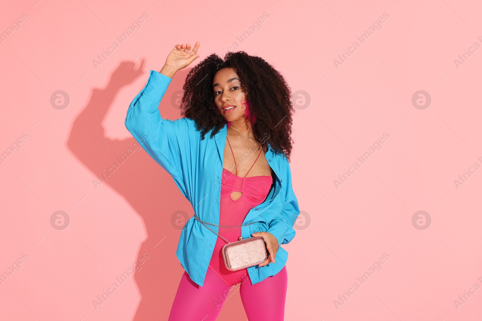 Fashionable portrait of beautiful Brazilian woman in stylish outfit on pink background Photo of Fashionable portrait of beautiful Brazilian woman in stylish outfit on pink background