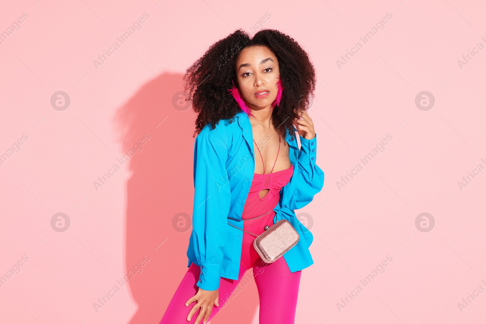 Fashionable portrait of beautiful Brazilian woman in stylish outfit on pink background Photo of Fashionable portrait of beautiful Brazilian woman in stylish outfit on pink background